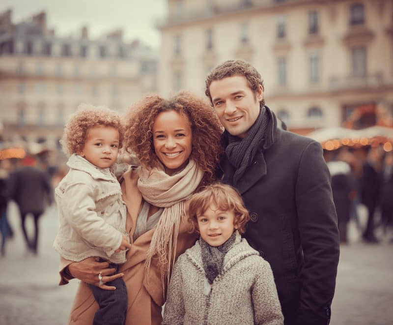 Famille de quatre personnes avec d’autres personnes derrière elle