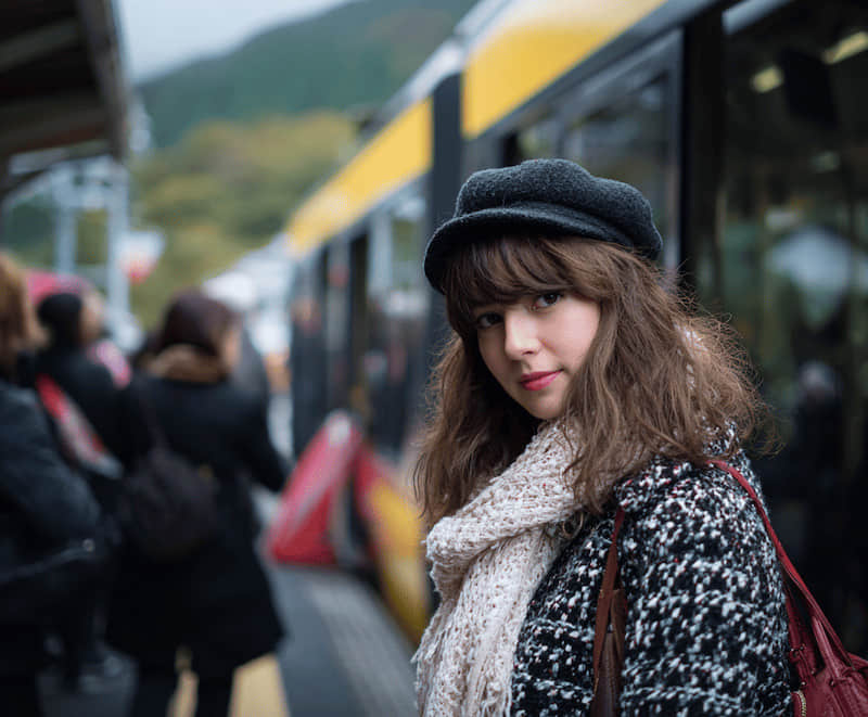 Portrait en gare avec des voyageurs derrière le sujet